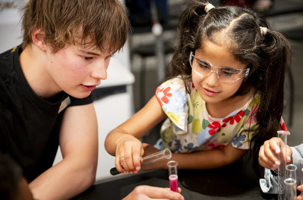 Aktiviteter för barn: ett barn gör kemiexperiment tillsammans med en pedagog