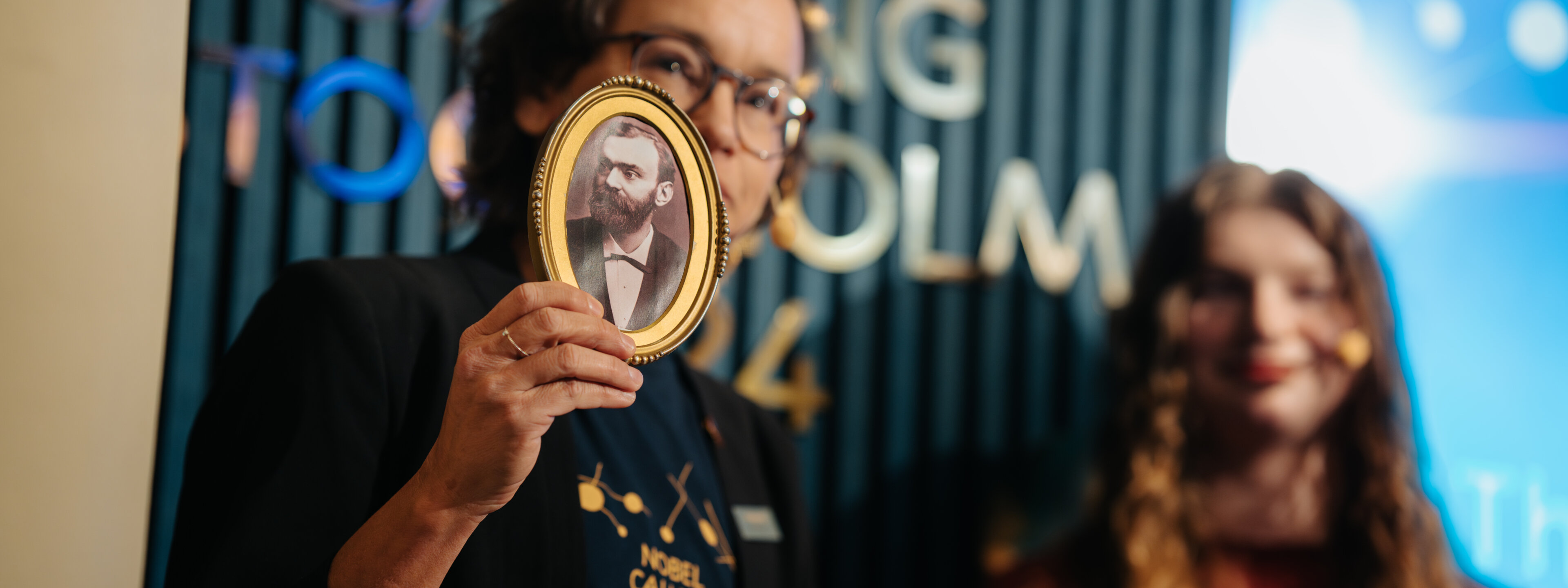 En person som håller i en bild av Alfred Nobel.